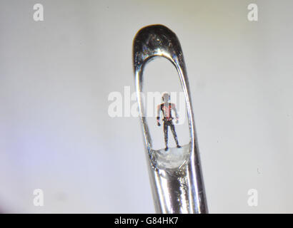 ANMERKUNG: AUFGENOMMEN MIT EINER MAKROLINSE DURCH DAS OKULAR EINES MIKROSKOPS EINE Mikroskulptur-Figur von Ant-man im Nadelöhr des britischen Künstlers Willard Wigan, während eines Fotoaufrufs für eine 4,5 m x 3,2 m große Miniaturkunstgalerie mit Kunstwerken aus dem neuen Film Ant-man, An der Old Street Station, London. Stockfoto