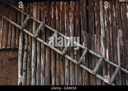 Holzleiter an Wand Stockfoto