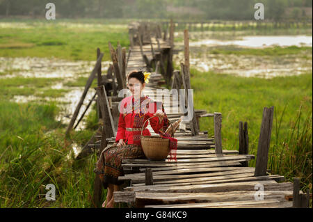 Porträt der Frau tragen traditionelle thai Kleidung sitzen auf Brücke Stockfoto