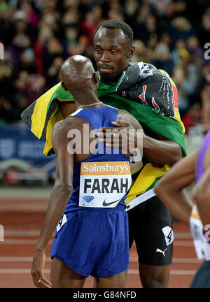 Der Brite Mo Farah gratuliert Jamaikas Usain Bolt zum Sieg beim 100-m-Finale der Männer am ersten Tag der Sainsbury's Anniversary Games im Stadion im Queen Elizabeth Olympic Park, London. Stockfoto