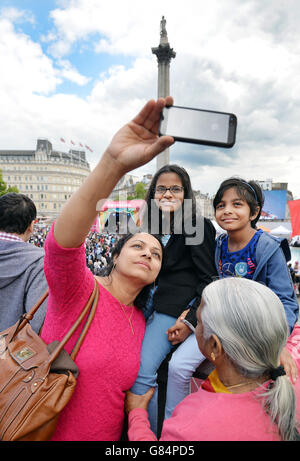 Mitglieder der Öffentlichkeit machen ein Selfie während des 10. Eid Festivals auf dem Trafalgar Square im Zentrum von London, um Live-Aufführungen von Musik und Tanz zu sehen, die das Ende des muslimischen Ramadan feiern. Stockfoto