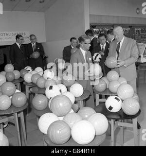 Der Präsident der FIFA, Sir Stanley Rous (rechts), sieht Fußbälle von sieben englischen und zwei ausländischen Herstellern in White City in London. Sie haben die Art des Fußballs ausgewählt, der im nächsten Jahr bei der Weltmeisterschaft eingesetzt werden soll, die in Großbritannien ausgetragen wird. Stockfoto