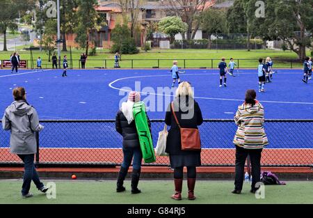 Übergeordneten Zuschauern ein junior fangen Sie Hockey-Spiel. Stockfoto