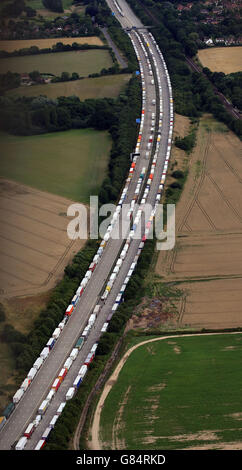 Lastwagen standen im Rahmen der Operation Stack entlang der Nord- und Südstraßen der M20 in Ashford, Kent, nach einem Tod von Migranten beim jüngsten Einfall auf den Kanaltunnel in Calais in Warteschlange. Stockfoto