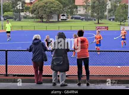 Übergeordneten Zuschauern ein junior fangen Sie Hockey-Spiel. Stockfoto