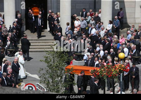 Trauernde beobachten, wie die Särge von Larry (hinten) und Martina (vorne) Hayes aus Athlone in den Irish midlands, die Opfer des Terroranschlags in Tunesien sind, nach ihrem Trauerdienst aus der Kirche der Heiligen Peter und Paul in Athlone getragen werden. Stockfoto