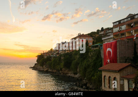 Sonnenuntergang über türkischen Dorf von Amasra mit großen türkischen Flagge auf dem Display von Wand Stockfoto