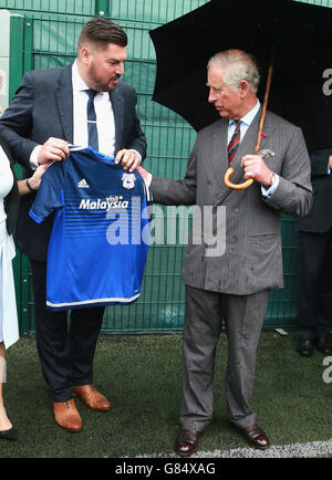 Der Prinz von Wales wird mit einem Cardiff City Fußballtrikot überreicht, nachdem er junge Straftäter bei einem Besuch im Parc Prison in Bridgend, Wales, an einem "Get Started with Football"-Programm des Prince's Trust teilgenommen hat. Stockfoto