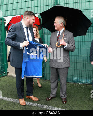 Der Prinz von Wales wird mit einem Cardiff City Fußballtrikot überreicht, nachdem er junge Straftäter bei einem Besuch im Parc Prison in Bridgend, Wales, an einem "Get Started with Football"-Programm des Prince's Trust teilgenommen hat. Stockfoto