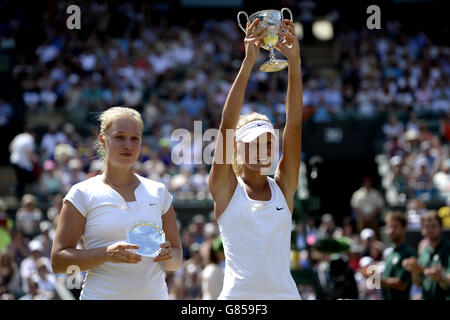 Sofya Zhuk (rechts) feiert mit der Mädchen-Einzel-Trophäe nach dem Sieg über Anna Blinkova (links) am 12. Tag der Wimbledon Championships im All England Lawn Tennis und Croquet Club, Wimbledon. Stockfoto