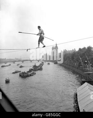 Der Franzose M Elleano überquert die Themse mit einer Seiltanz und endet am South Bank-Standort der Festival Exhibition. Obwohl er nicht schwimmen kann, hat er mit dieser Methode bereits den Rhein überquert und hofft, das auch bei Niagra zu tun. Im Hintergrund sind Big Ben und das Parlamentsgebäude zu sehen. Stockfoto