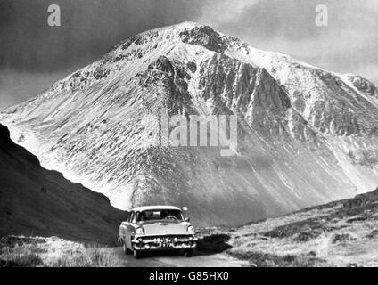 Ein Ford Mercury Auto fährt durch den Lake District und entdeckt die fast alpine Winterschönheit am Great Gable, einem der beliebtesten Klettergipfel Großbritanniens. Stockfoto