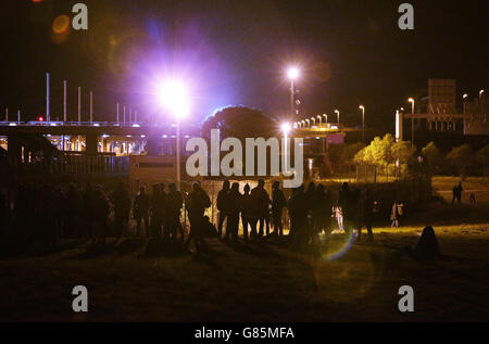 Migranten, die am Perimeter-Sicherheitszaun des Eurotunnel-Geländes in Coquelles in Calais, Frankreich, stehen. DRÜCKEN Sie VERBANDSFOTO. Bilddatum: Mittwoch, 29. Juli 2015. Bildnachweis sollte lauten: Yui Mok/PA Wire Stockfoto