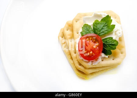 Gesunden low Carb Frühstück Snack auf weiße Schale, Cracker und frischen Tomaten auf Frischkäse mit Petersilie Stockfoto