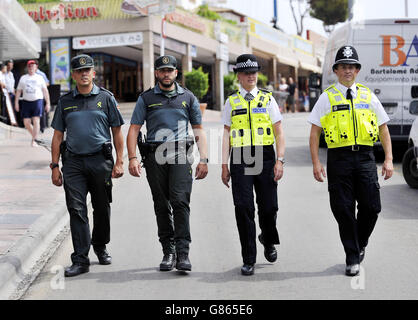 West Midlands Polizeibeamte, PC Martina Anderson und Sergeant Brett Williams (beide rechts), schließen sich spanischen Kollegen in Punta Ballena, dem Hauptclubstrip in Magaluf, Mallorca, Spanien, gleich nach Mittag Ortszeit, bevor es nachts voll wird, an. Während eines vom Auswärtigen Amt finanzierten Prozesses zur Patrouille touristischer Hotspots, einschließlich Strände, Flughafenterminals und Stadtzentren, . Stockfoto