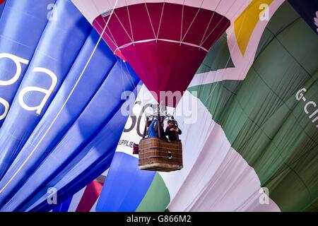Im Vorfeld der Bristol International Balloon Fiesta fliegen Heißluftballons über das Stadtzentrum von Bristol, wo sich Hunderte von Ballonfahrern über den Himmel von Bristol und Somerset versammeln, um vier Tage lang Ballonfeste zu feiern und zu fliegen. Stockfoto