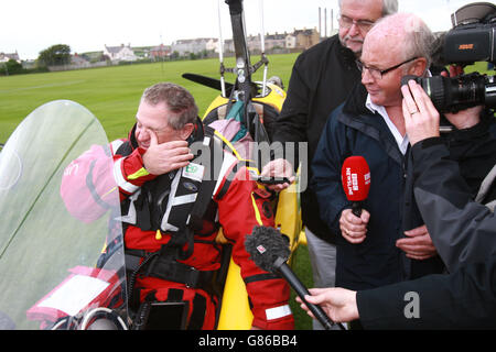 Der nordirische Abenteurer Norman Surplus, der im Gyrocopter einen Rekordflug um die Welt absolviert hat, trifft fünf Jahre nach seinem Start auf dem Cricket-Platz im Bay Park in seiner Heimatstadt Larne ein. Stockfoto