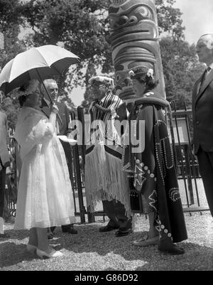 Königin Elizabeth, die Königin Mutter, die für Königin Elizabeth II. Stellvertretend war, spricht mit Chief Mungo Martin und seiner Enkelin Helen Hunt, nachdem sie den 100 Meter langen Totem-Stock, ein Geschenk von British Columbia, im Windsor Great Park erhalten hatte. Der Häuptling Mungo Martin der Kwakiutl-Indianer, ein Stamm auf Vancouver Island, hat die aufwendigen Ornamente auf dem 12-Tonnen-Pol geschnitzt. Das Geschenk der Totempfange an Königin Elizabeth II. Markiert den 100. Jahrestag von British Columbia. Stockfoto
