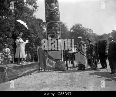 Königin Elizabeth, die Königin Mutter, die für Königin Elizabeth II. Stellvertretend war, enthüllt die Gedenktafel am Fuß des 100 Meter langen Totempostens, der als Geschenk von British Columbia im Windsor Great Park errichtet wurde. Beobachten sind Chief Mungo Martin, der Kwakiutl Indianer, ein Stamm auf Vancouver Island, und seine Enkelin, Helen Hunt. Chief Mungo Martin hat die aufwendige Verzierung auf dem 12-Tonnen-Pol geschnitzt. Stockfoto
