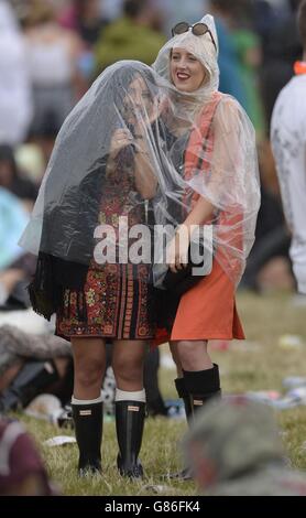 Festivalbesucher schützen sich vor dem Regen während des ersten Tages des V Festivals, im Weston Park, Shifnal, Shropshire. Stockfoto