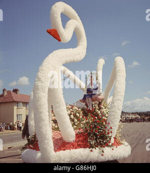 Swantasia, ein Schwan-Blumenwagen während der Battle of Flowers, Jersey, Channel Island. Stockfoto