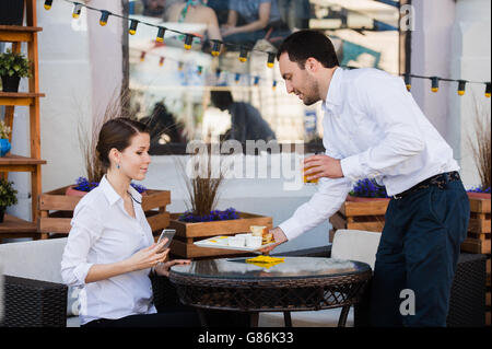 Kellner-Server am Tisch arbeiten Menü Specials Leseliste für Gruppe von Personen Stockfoto