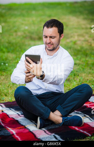 Moderne junge hispanic Mann unter ein Selbstporträt im Park, mit seinem Tablet. Stockfoto