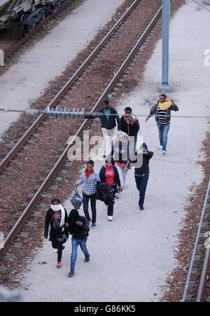 Migranten machen ihren Weg auf Schienen in der Nähe des Eurotunnel-Geländes in Coquelles in Calais, Frankreich. Stockfoto