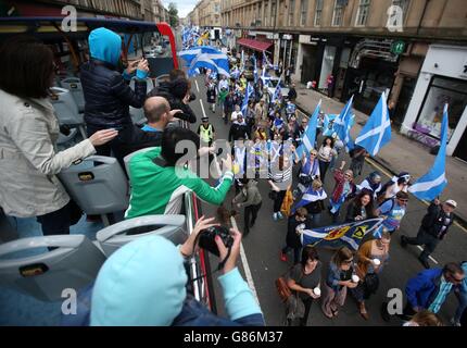 Mitglieder der Öffentlichkeit auf einer Tour Bus Welle als ein Pro-Unabhängigkeit-marsch vorbeizieht, wie sie in Glasgow von Kelvingrove Park zu Glasgow Green marschieren. Stockfoto