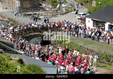 Die Prozession überquert eine Brücke in Boscastle. Die von Überschwemmungen heimgetragenen Gemeinde Boscastle versammelten sich, um den 1. Mai zu feiern und die Erholung des Dorfes seit dem verheerenden Sturzregen des letzten Sommers zu markieren. Stockfoto