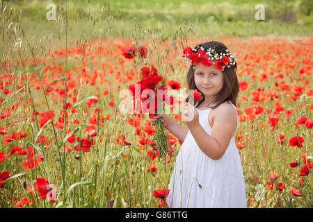 Mädchen halten Mohn Blumen im Feld Stockfoto