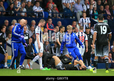 Der Chelsea-Arzt Chris Hughes (Mitte rechts) und der Physiotherapeut Steven Hughes (links) betreten das Spielfeld, um Branislav Ivanovic (Boden) während des Spiels der Barclays Premier League im Hawthorns, West Bromwich, zu behandeln. Stockfoto