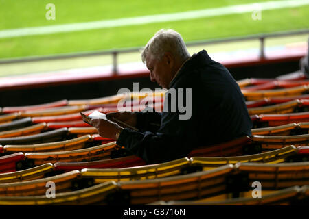 Fußball - Capital One Cup - zweite Runde - Luton Town / Stoke City - Kenilworth Road. Ein Fan von Luton Town liest das Spieltagsprogramm Stockfoto