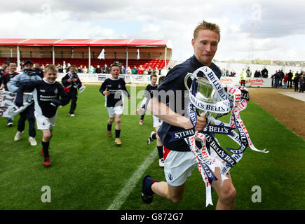 Falkirks Daniel McBreen wird von Mitgliedern der Falkirk's Community verfolgt Teams mit der Scottish Football League Frist Division Trophy Stockfoto