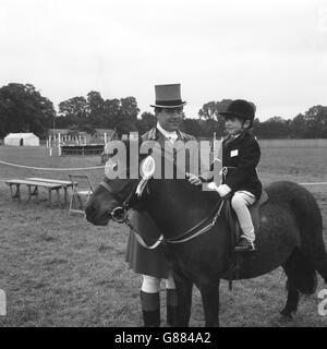 Ron Hill, aus Slough, der bei den meisten wichtigen Pferdeshows als Ringwächter tätig war, mit seiner Tochter Jane, die in der Klasse für Kinderpony auf der Royal Windsor Horse Show ihr eigenes Bambi reitet. Stockfoto