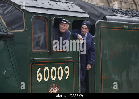 Eisenbahner schauen aus dem Fahrerhaus der Dampflokomotive Union of South Africa kommt in Edinburghs Waverley Station an, um Queen Elizabeth II zu tragen, an dem Tag, an dem sie Großbritanniens längste regierende Monarch wird, und ihr Ehemann, Prinz Philip, auf einer Reise, um die neue &pound;294 Million Scottish Borders Railway einzuweihen. Stockfoto