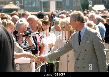 Der Prinz von Wales und die Herzogin von Cornwall grüßen auf der Hafenmauer in St. Marys, auf ihrem Weg zu einem Motorboot nach St. Agnes lsland. Stockfoto