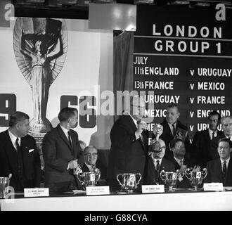 Sir Stanley Rous, Präsident der FIFA, hält den Jules Rimet Cup im Royal Garden Hotel in Kensington ab, wo er die Verlosung für den im Juli in England stattfindenden Wettbewerb leitete. Mit ihm am Tisch sind (l-r) SL Mordy Maduro, Helmet Kaeser, Harry H Cavan und der Earl of Harewood. Stockfoto