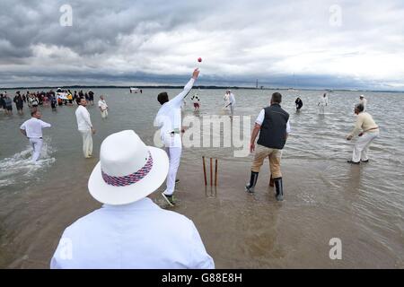 Spielaction während des jährlichen Cricket-Spiels der Bramble Bank zwischen dem Royal Southern Yacht Club und dem Island Sailing Club, das bei Ebbe auf einer Sandbank mitten im Solent stattfindet. Stockfoto