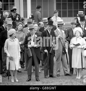 Sowohl Queen Elizabeth II (l), gesehen, im Chat mit dem Herzog von Norfolk, und die Königin Mutter (ganz rechts) hatten Regenschirme, als sie die Parade der Läufer für die Oaks Stakes bei Epsom Races beobachtete. Stockfoto