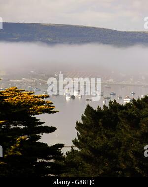 Tief liegender Nebel über Sandbanks am Eingang zum Hafen von Poole in Dorset umhüllt die Purbeck Hills in der Ferne. Stockfoto