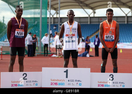 (l-r) Emmanuel Odobanjo aus England, Jude Bright-Davis aus England und Wesley Matsuka-Williams aus England Midland erhalten bei der Medaillenzeremonie bei den Schulspielen von Sainsbury 2015 in der Manchester Regional Arena die dreifachen Sprungmedaillen ihrer Jungen. Stockfoto