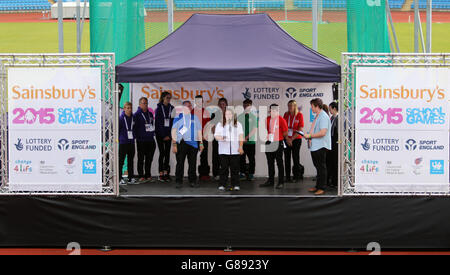 Athleten, Beamte und Freiwillige sprechen auf der Bühne bei der Abschlusszeremonie für die Sainsbury's 2015 School Games in der Regional Arena, Manchester. Stockfoto