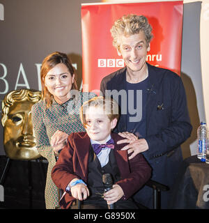Jenna Coleman und Peter Capaldi posieren für ein Foto mit George Buckland, 11, aus Nottingham, auch bekannt als 'Mini Matt Smith', nachdem er mit der Besetzung auf die Bühne eingeladen wurde und um seine Aufnahme mit den Schauspielern von Cineworld in Cardiff bat, Wo Episoden für die neue DR Who-Serie gescreent werden. Stockfoto