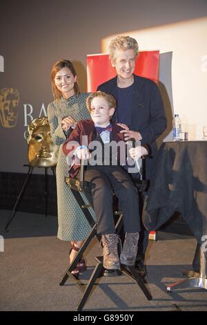 Jenna Coleman und Peter Capaldi posieren für ein Foto mit George Buckland, 11, aus Nottingham, auch bekannt als 'Mini Matt Smith', nachdem er mit der Besetzung auf die Bühne eingeladen wurde und um seine Aufnahme mit den Schauspielern von Cineworld in Cardiff bat, Wo Episoden für die neue DR Who-Serie gescreent werden. Stockfoto