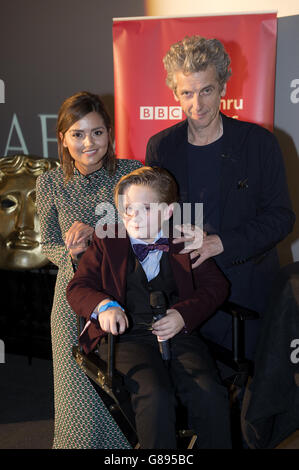 Die Schauspieler Jenna Coleman und Peter Capaldi posieren für ein Foto mit George Buckland, 11, aus Nottingham, auch bekannt als 'Mini Matt Smith', nachdem er mit der Besetzung auf die Bühne eingeladen wurde und um seine Aufnahme mit den Schauspielern bat Stockfoto