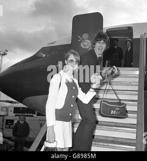 George Harrison von den Beatles und seine neue Frau Patti besteigen am Londoner Flughafen ein Flugzeug. Dort flogen sie auf ihren Flitterwochen nach Barbados. Stockfoto