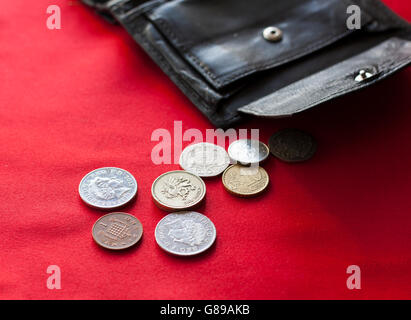 Britische Pfund und Euro-Cent Münzen verschütten aus offenen schwarzen Lederetui. Stockfoto