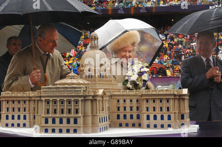 Britians Queen Elizabeth II (Mitte) schneidet mit dem Herzog von Edinburgh (links) und dem Premierminister von Alberta, Ralph Klein (rechts), einen Kuchen in Form des Legislativgebäudes von Alberta, Kanada. Während ihres Besuchs im Commonwealth Stadium zur Hundertjahrfeier von Edmonton. Stockfoto