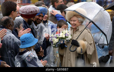 Die britische Königin Elizabeth II. Begrüßt die Menschenmassen in einem von Regen durchfluteten Stadion während der Centennial Celebration von Edmonton. Stockfoto